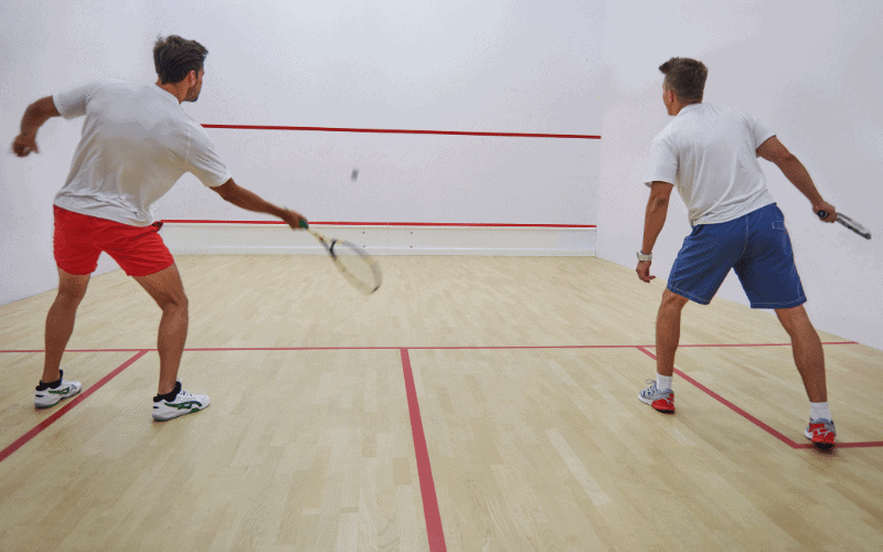 A squash player practices footwork and stretching to prevent injuries before a match