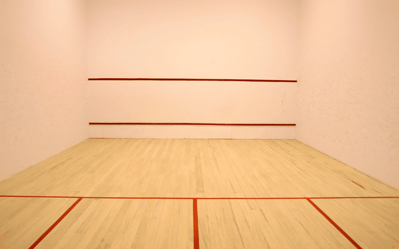 A squash court with German flags and trophies on display